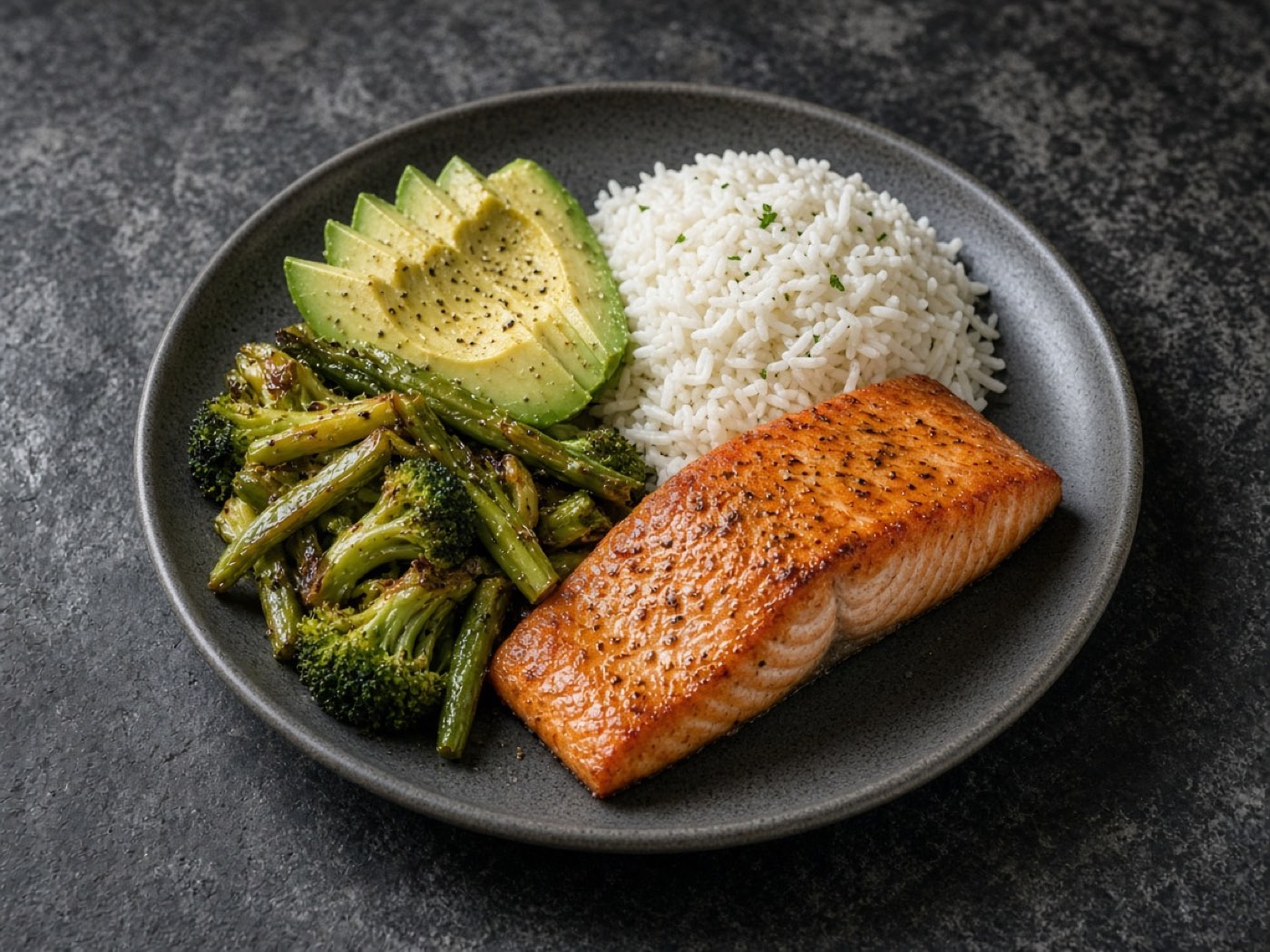 A plate of salmon, rice, avocado, and vegetables.